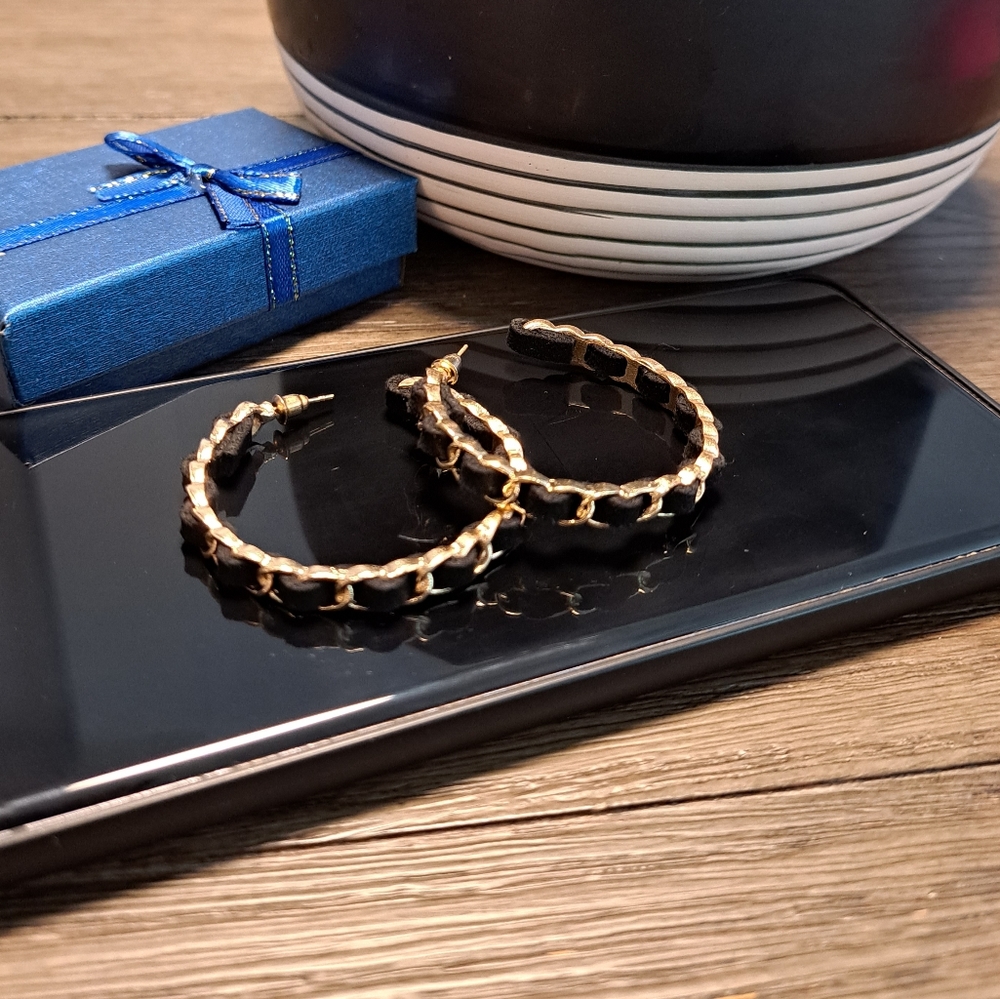 Fashion earrings in gold with black velvet strand in between.